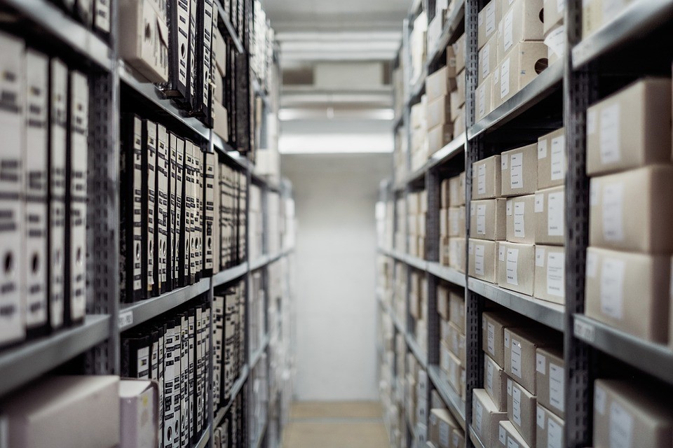 stacks in a library, showing books on one side and boxes on another