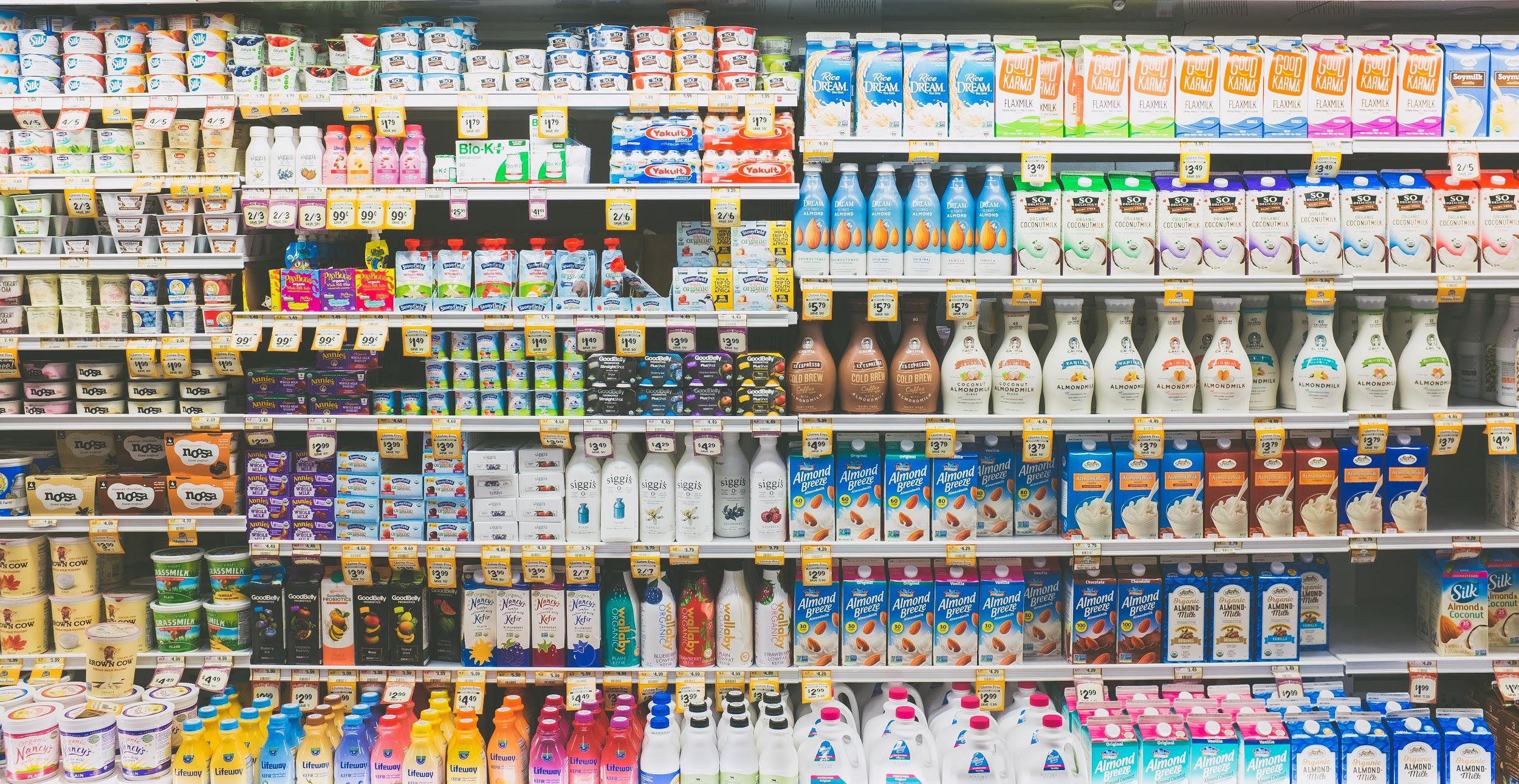 photo of a refrigerated grocery case containing many choices of yogurt, kefir, milk, and plant-based beverage products.