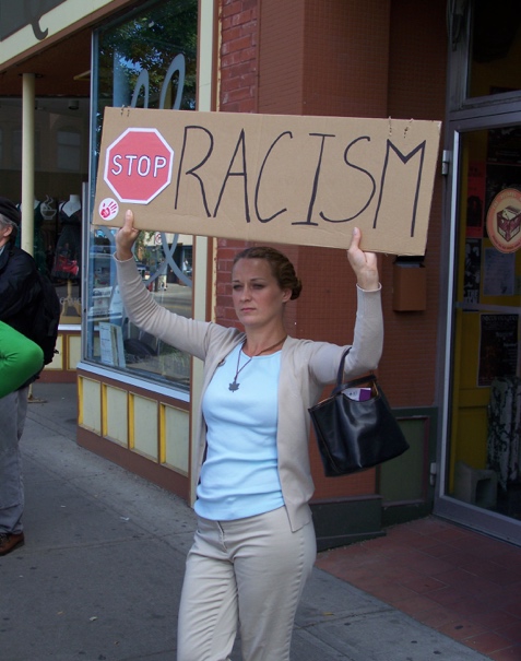 Woman with a, "stop racism," sign