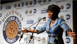 News reporter speaking at a podium with a microphone