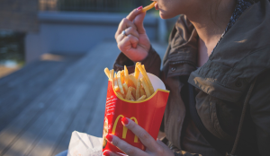 Person holding McDonald's fries and eating one