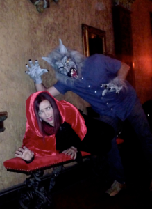 Two people dressed as Little Red Riding Hood and a Wolf posing as if the wolf is about to eat Little Red Riding Hood