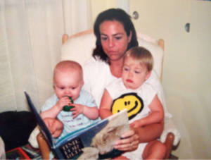 A mother reads a book to two children