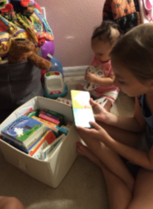 Two children looking through a box of books